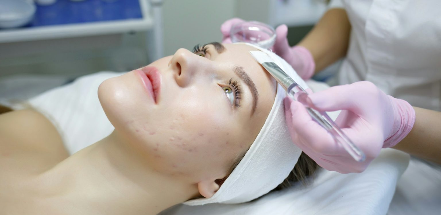 cosmeiologisat-applies-a-mask-to-a-young-woman-with-acne-e1721640412657-1536x750